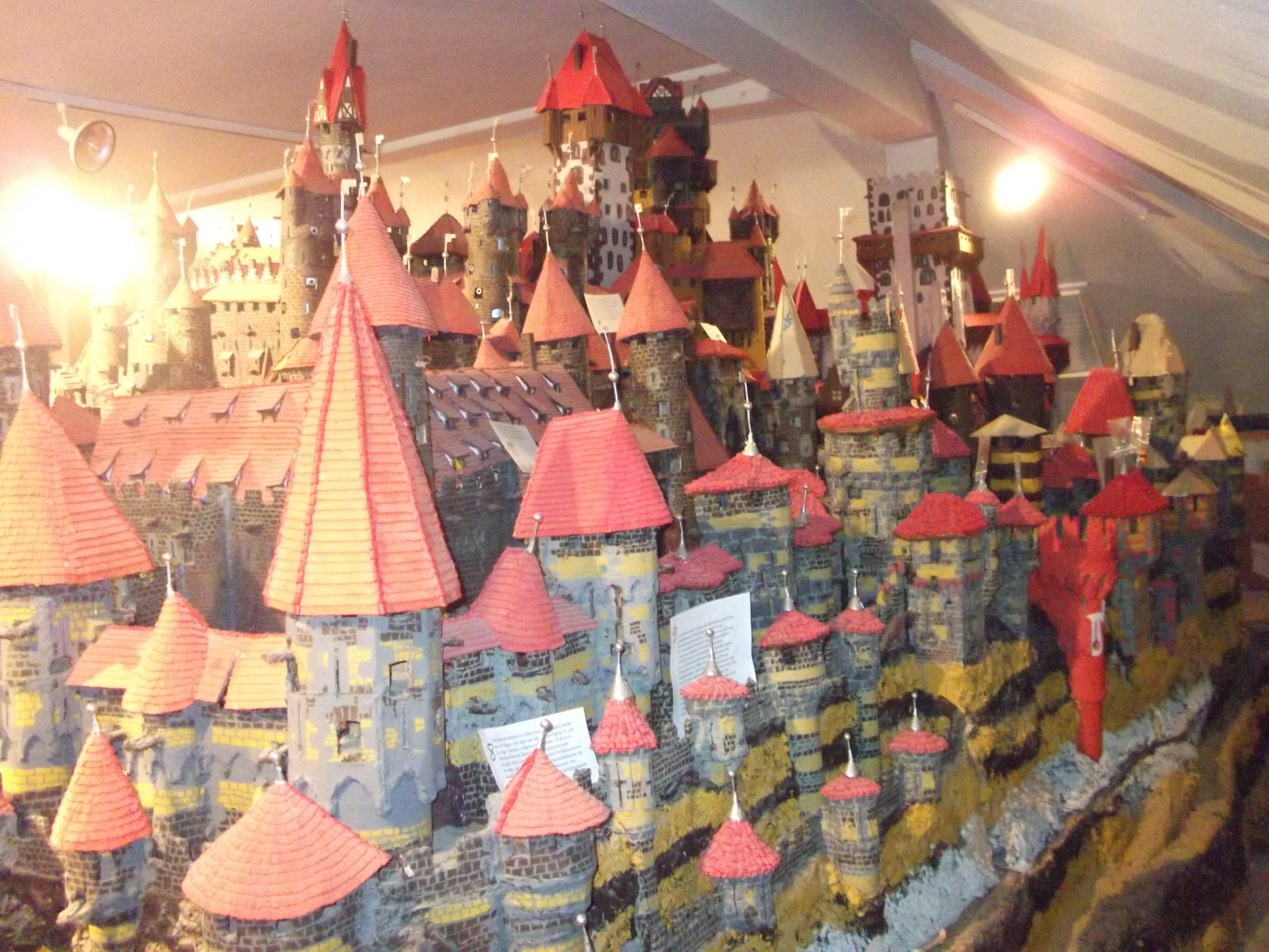 Burgmodell im Burgmuseum Wattenheim Großes Modell einer mittelalterlichen Burg mit vielen runden Türmen und roten Dächern in einem Ausstellungsraum.